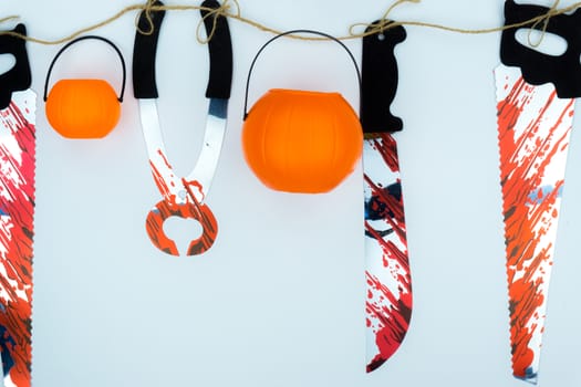 Top view of Halloween decoration, jack o lantern, and bloodstain on the knife and saw on white background with copy space for text. halloween concept.