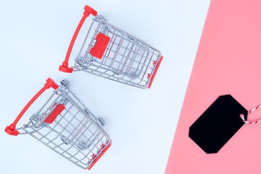 Online shopping of China, The shopping cart and Christmas boxes and shopping tag on a pink and white background with copy space for text. 11.11 single's day sale concept