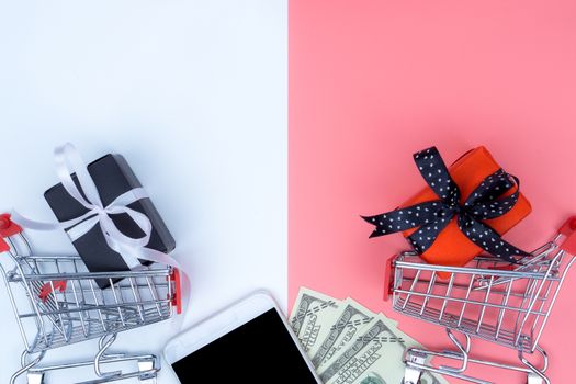 Online shopping of China, The shopping cart and Christmas boxes with black ribbon and smartphone and banknote on a white background with copy space for text. 11.11 single's day sale concept