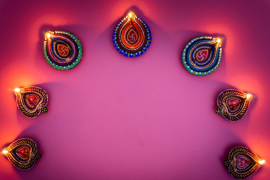 Indian festival Diwali, Diya oil lamps lit on colorful rangoli. Hindu traditional. Happy Deepavali. Copy space for text.