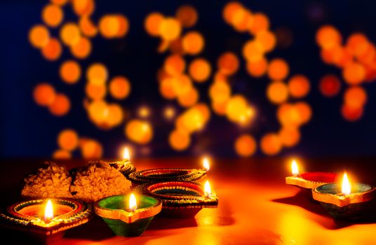 Indian festival Diwali, Diya oil lamps lit on colorful rangoli. Hindu traditional. Happy Deepavali. Copy space for text.