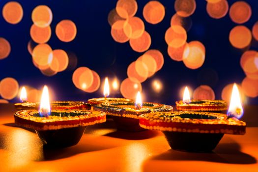 Indian festival Diwali, Diya oil lamps lit on colorful rangoli. Hindu traditional. Happy Deepavali. Copy space for text.