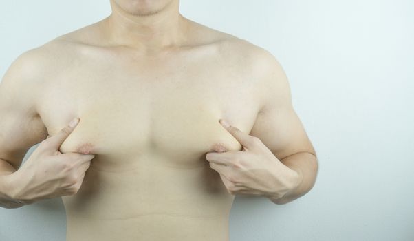 Close up man holding men boobs on white background. Diet, weight loss, slim body, healthy lifestyle concept.