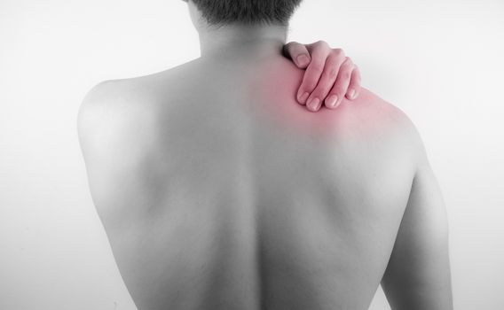 A man feeling exhausted and suffering from neck and shoulder pain and injury on white background. Healthcare and medical concept.