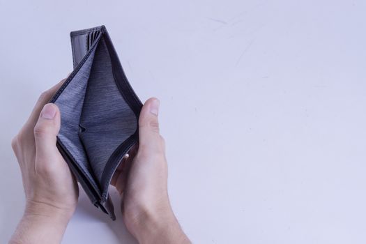 A man holds an empty wallet in his hands on a white background. Finance problem and bankruptcy concept.