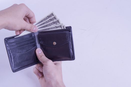 Man hand taking out the money for payment from the black leather wallet. Finance and money concept, copy space for text.