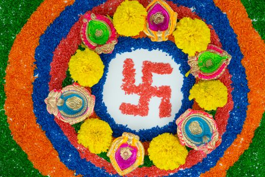 Indian festival Diwali, Diya oil lamps lit on colorful rangoli with Swastika symbol. Hindu traditional. Happy Deepavali.