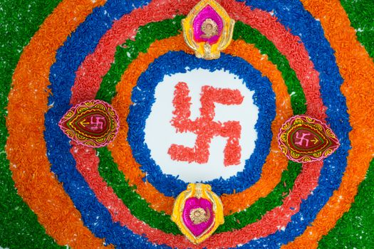 Indian festival Diwali, Diya oil lamps lit on colorful rangoli with Swastika symbol. Hindu traditional. Happy Deepavali.