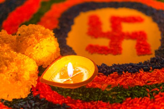 Indian festival Diwali, Diya oil lamps lit on colorful rangoli with Swastika symbol. Hindu traditional. Happy Deepavali.