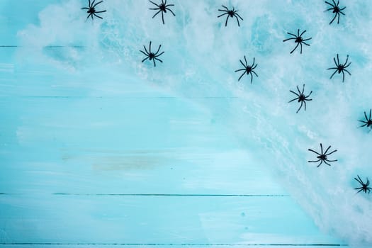 Halloween holiday background with spider and webs on blue wooden table with copy space for text. Flat lay, top view