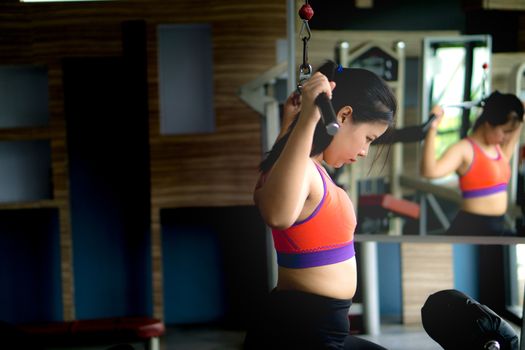 Asian beauty woman doing exercise for back. Working out on a lat pulldown machine. Diet, weight loss, slim body, healthy lifestyle concept.