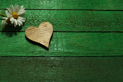 The picture shows a flower and a heart on green boards