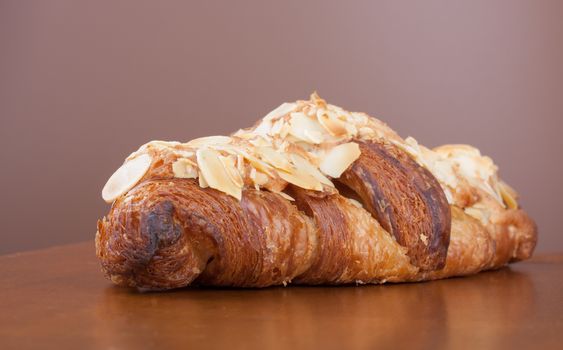 Close-up on tasty French almond crescent on wood table