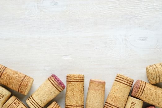 Set of used wine bottle corks, sitting on white table surface, viewed from above with copy space