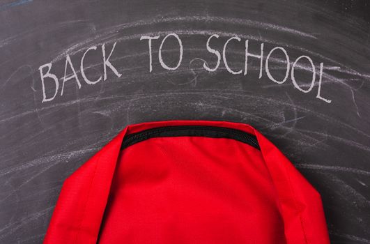 Back to school shopping pocket backpack on the education red bag on blackboard and chalkboard