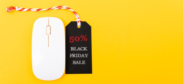 Online shopping Black Friday sale text red tag on white mouse with yellow background