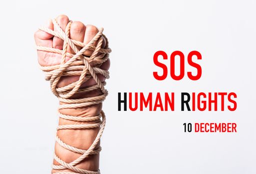 Rope on fist hand with SOS HUMAN RIGHTS DAY 10 december text on white background, Human rights day concept