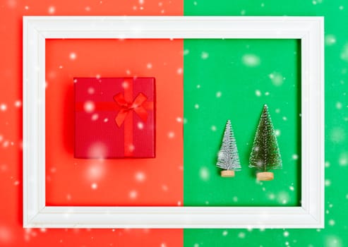 New Year, Christmas Xmas holiday composition, Top view green fir tree branch and red gift box in frame on red and green background with copy space