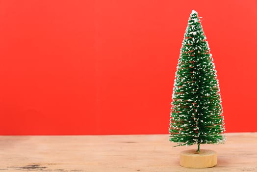 Christmas composition decorations, minimal green fir tree branches with snow on red background. Merry Christmas concept. Copy space for text
