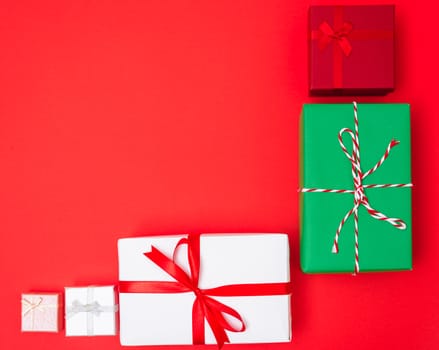 Happy New Year and Christmas 2020 day, top view Xmas multi color gift boxes on red background with copy space for your text
