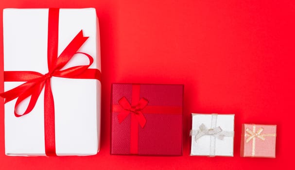 Happy New Year and Christmas 2020 day, top view Xmas multi color gift boxes on red background with copy space for your text
