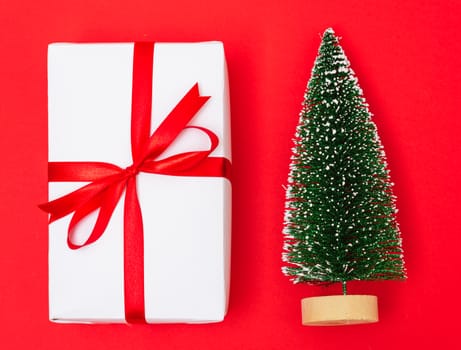 Happy New Year and Christmas 2020 day, top view Xmas white gift boxes & fir tree on red background with copy space for your text