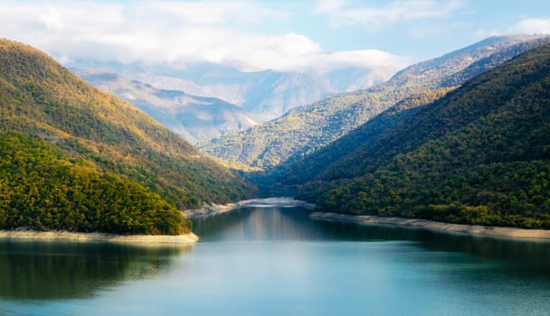 autumn mountain landscape with green forest and lake and sky and clouds in Georgia