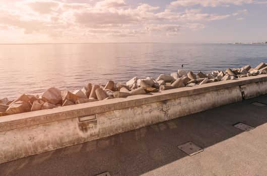 Coastline with concrete wave breaker in the shape of rocks