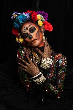 Closeup portrait of woman with a sugar skull makeup dressed with flower crown. Halloween concept