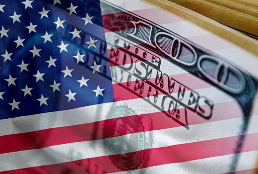 100 dollar bill with American Flag overlay in a conceptual image of currency exchange, trade, finances and the economy in the United States of America