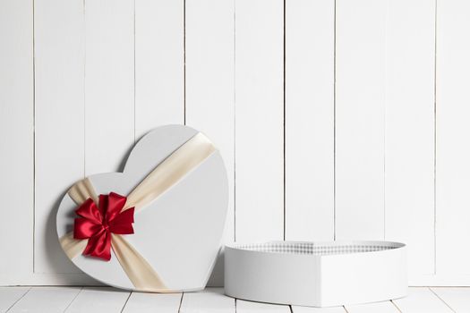 Heart shaped Valentines Day gift box on white wooden background