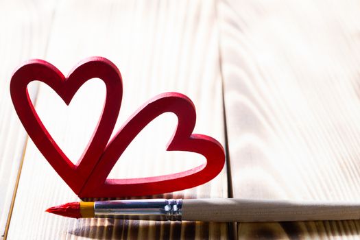 Painted heart and paint brush on wooden table, Valentines day gift concept