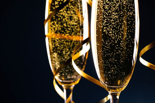 Two glasses of champagne and ribbons on dark blue background, Happy New Year, romance, evening, dating, Valentines day concept