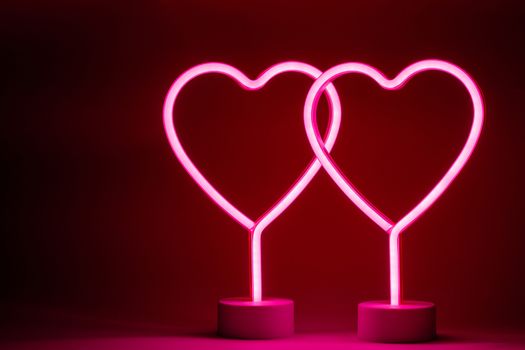 Two glowing pink neon hearts Valentines day party concept