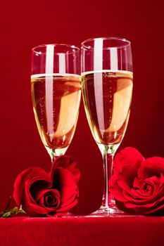 Champagne and red heart shaped roses on red background