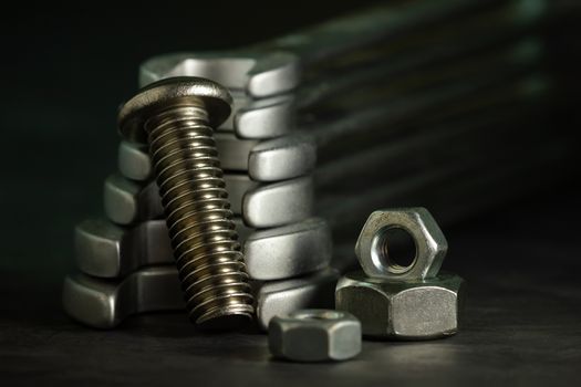 Bolt nuts and wrench on cement floor in darkness. Closeup and copy space for text. Concept of mechanical engineering jobs.