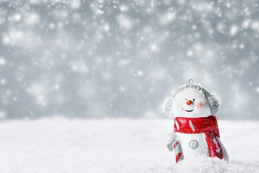 Christmas Snowman toy on winter background in the snow
