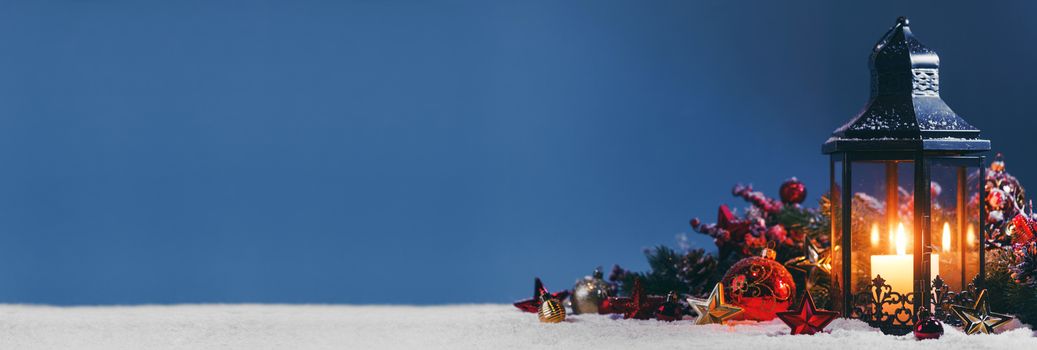 Christmas composition of lantern colorful ornaments balls stars candles and fir tree branches on snow