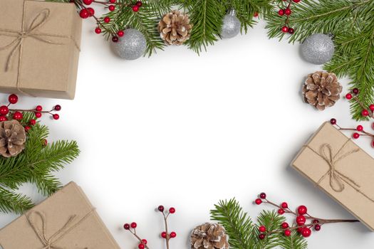 Christmas tree branch with snow , pine cones, red berries and gift boxes on white background with copy space
