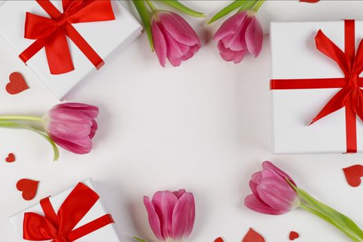 Pink tulip flowers gifts and red hearts composition on white background top view with copy space. Valentine's day, birthday, wedding, Mother's day concept. Copy space