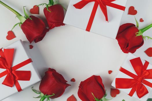 Red rose flowers gifts and red hearts composition on white background top view with copy space. Valentine's day, birthday, wedding, Mother's day concept. Copy space