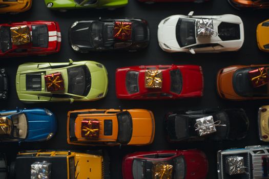 Traffic jam of toy cars carrying holiday gifts or black friday sale purchase top view