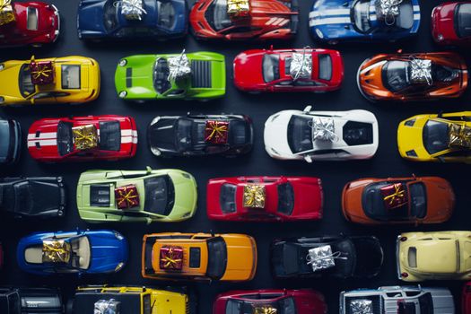 Traffic jam of toy cars carrying holiday gifts or black friday sale purchase top view