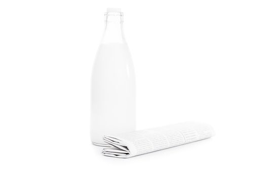 Close up shot of a rolled up newspaper and an old school bottle of milk, isolated on white background.