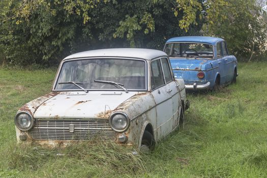 two old cars abandoned in the yard