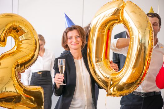 Business people are celebrating holiday in modern office drinking champagne and having fun in coworking. Merry Christmas and Happy New Year 2020 concept