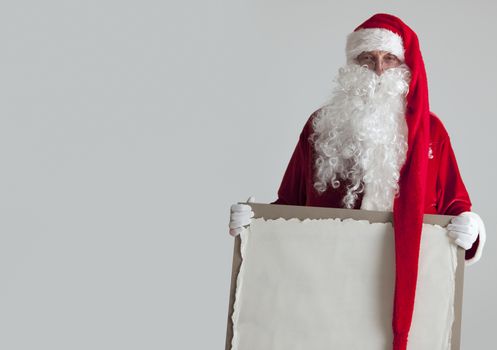 Santa Claus holding vintage paper billboard with copy space for text on gray background