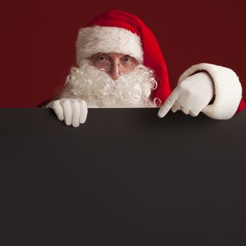 Santa Claus holding black paper billboard with copy space for text