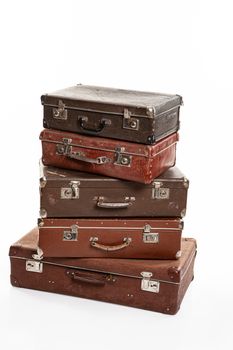 Five old suitcases on an isolated studio background
