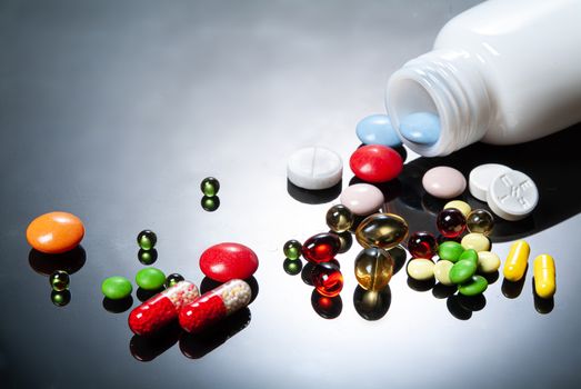 Different coloured drugs on a studio glass background